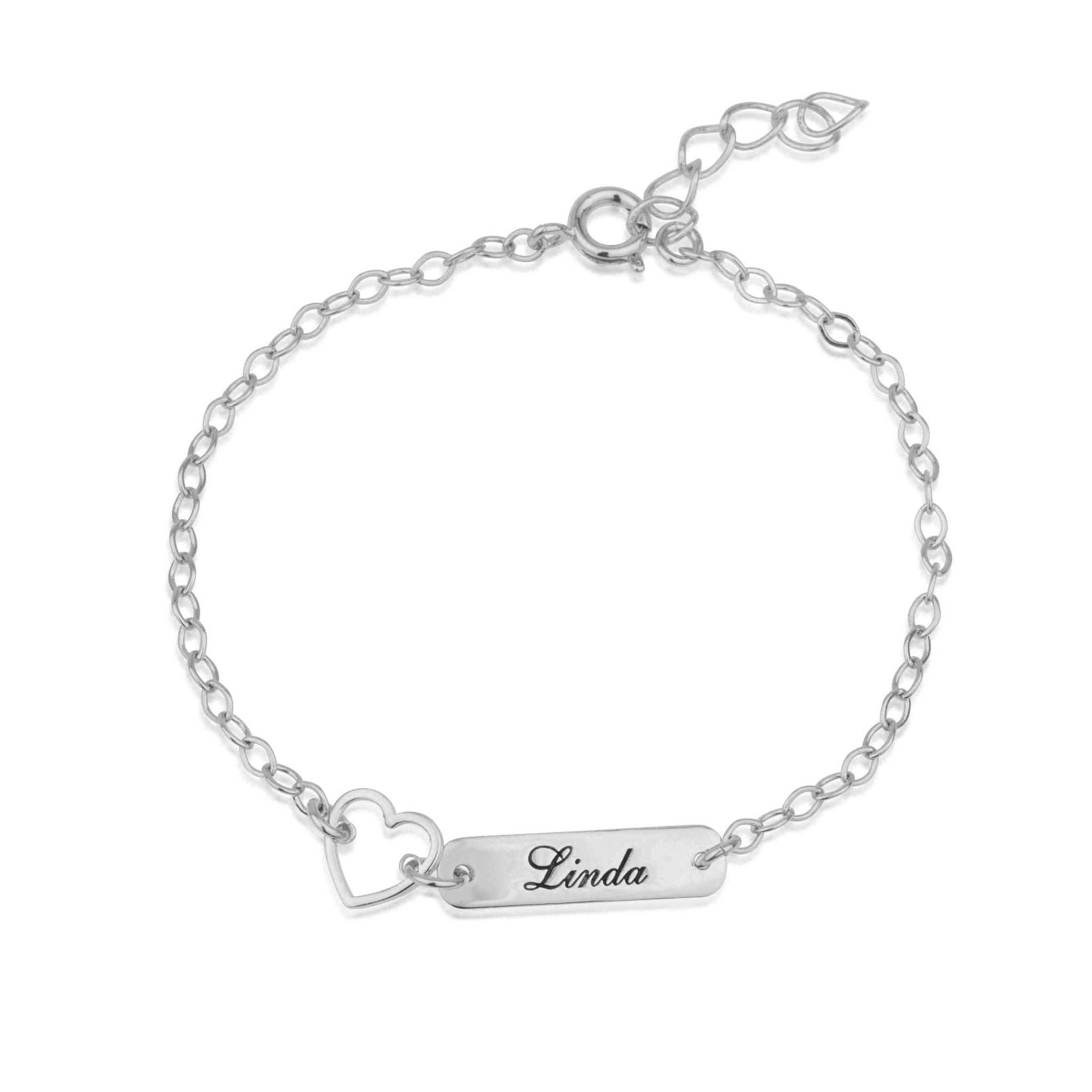 A silver chain bracelet with a rectangular bar engraved with the name 'Linda' and a dangling heart charm, shown on a plain white background.